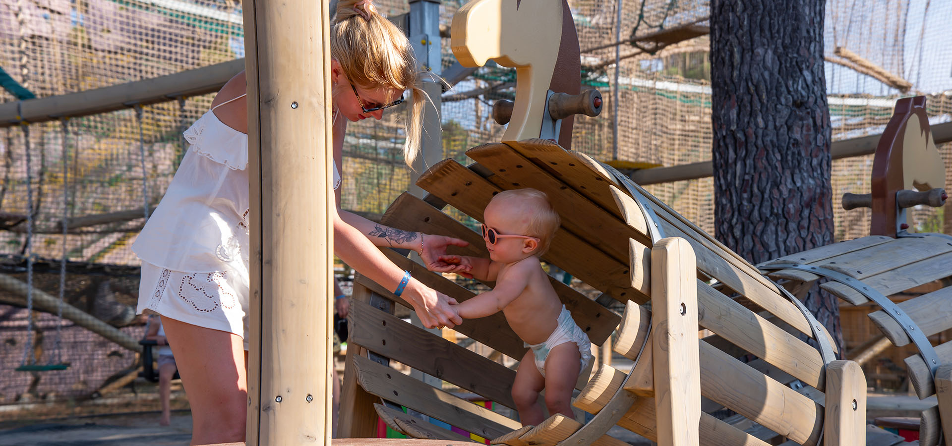 Camping san damiano aire de jeux bebe avec sa mere dans tonneau